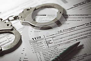 Tax evasion concept - tax form 1120 and handcuffs photo