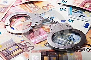Tax evasion, corruption concept - handcuffs on euro money bills photo