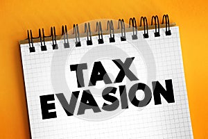 Tax Evasion is an illegal attempt to defeat the imposition of taxes by individuals, corporations, trusts, text concept on notepad