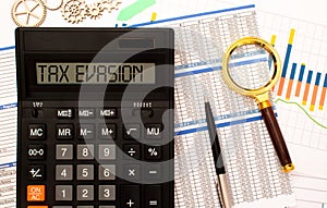 Tax evasion message on calculator in hand of businessman