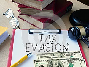 Tax evasion is shown using the text and photo of dollars and gavel