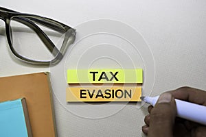 Tax Evasion text on sticky notes isolated on office desk photo