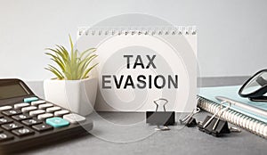Tax Evasion text on sticky notes isolated on office desk photo