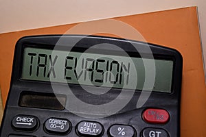 Tax Evasion write on the calculator on Office Desk photo