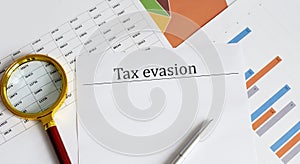 Tax evasion written on a paper whith charts photo