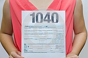 1040 tax forms in female hands. Business woman holding a tax form in her hands 1040. Close-up.