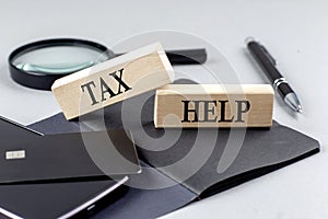 TAX HELP text on wooden block on black notebook , business concept