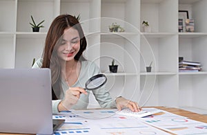 Tax inspector and financial auditor looking through magnifying glass, inspecting company financial papers, documents and