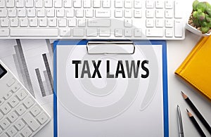 TAX LAW written on paper with keyboard, chart, calculator and notebook