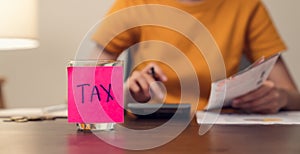 TAX notepaper pasted on the bottle with coins inside.