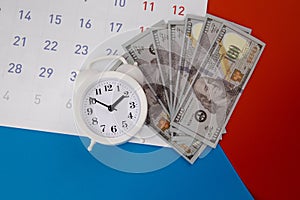 Tax payment season and finance debt collection deadline concept. Dollar banknotes, calendar and white clock