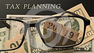 Tax planning concept. Glasses, number 2019, Tax planning words