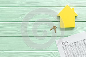 Tax for property accounting with house figure, keys and table on mint green wooden background top view copyspace