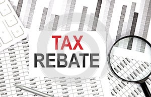 Tax rebate text on paper with calculator,pen on graph background