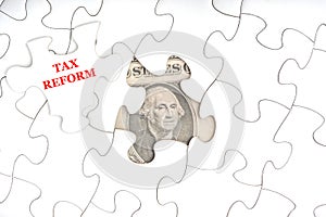 TAX REFORM text with Dollar banknotes on white jigsaw puzzle