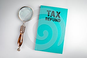 Tax Refund. Green book cover and magnifying glass