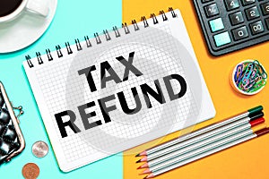 TAX REFUND with the office tools on yellow blue background . Concept TAX REFUND