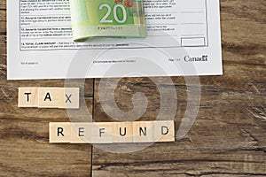 Tax refund spelled out in letters with Canadian Dollar cash in background