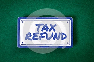 TAX REFUND. Sticky note with text on a green background