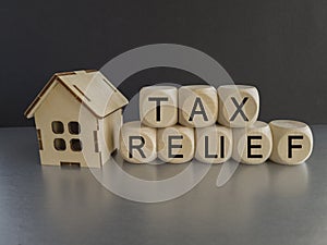 Tax relief symbol. Concept words \'tax relief\' on wooden blocks on gray table.