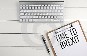 TAX RELIEF text on paper clipboard with magnifier and keyboard on wooden background