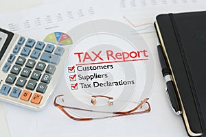 Tax report on a desk with tick against customers, suppliers and tax declarations