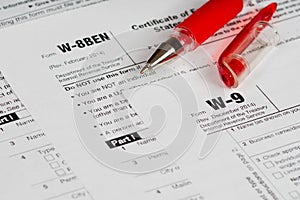 Tax reporting forms with red pen