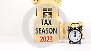 Tax season 2023 symbol. Concept words Tax season 2023 on wooden blocks on a beautiful white table white background. Black alarm