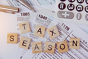 Tax season with wooden alphabet blocks, calculator, pen on 1040 tax form background