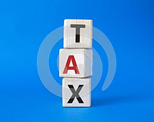 Tax symbol. Wooden cubes with word Tax. Beautiful blue background. Business and Finace and Tax concept. Copy space