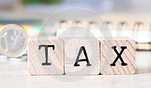 TAX text on wooden cubes on the wooden background. Tax Business Concept