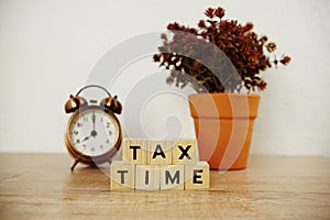 Tax Time and alarm clock with space copy on wooden background