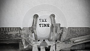 TAX TIME text on blank sheet with an old typewriter in vintage background