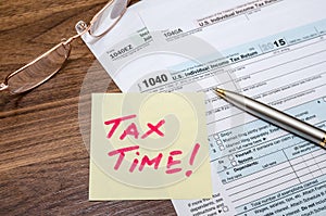 Tax time word on tax form with calculator, pen