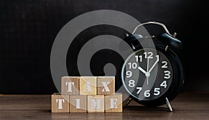 TAX TIME word on wood cube block with clock