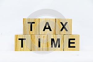 Tax time written on wooden block on white background. Conseptual.