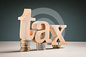 TAX word on a small heap coins, Tax Burden