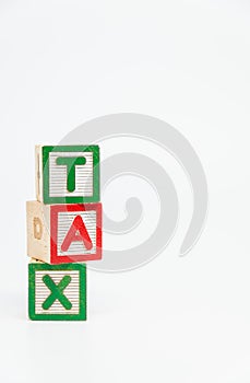 TAX word wooden block arrange in vertical style on white background and selective focus