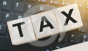 Tax Word On Wooden Blocks on computer keyboard. Tax payment online business concept