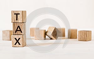 Tax word on wooden blocks on light background