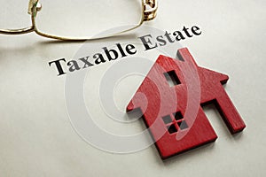 Taxable estate. House model and glasses on paper. photo