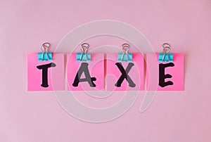 Taxe text on a pink sticker and on pink background