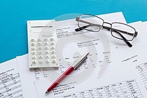 Taxes calculation concept. Financial documents, calculator, glasses on blue background