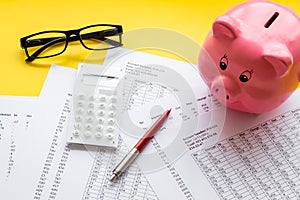 Taxes calculation concept. Financial documents, piggy bank, calculator on yellow background