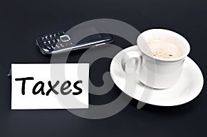 Taxes message on desk with coffee