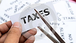 Taxes text or word meaning on paper in hand holding photo