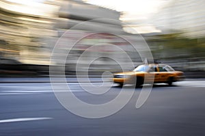 Taxi cab speeding down street in a blur