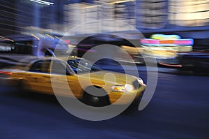 Taxi cab speeding down street in a blur