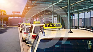 Taxi cabs waiting for passengers. Yellow taxi sign on cab cars. Taxi cars waiting arrival passengers in front of Airport Gate. photo