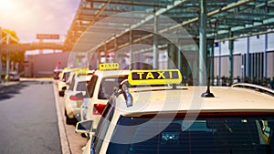 Taxi cabs waiting for passengers. Yellow taxi sign on cab cars. Taxi cars waiting arrival passengers in front of Airport Gate.